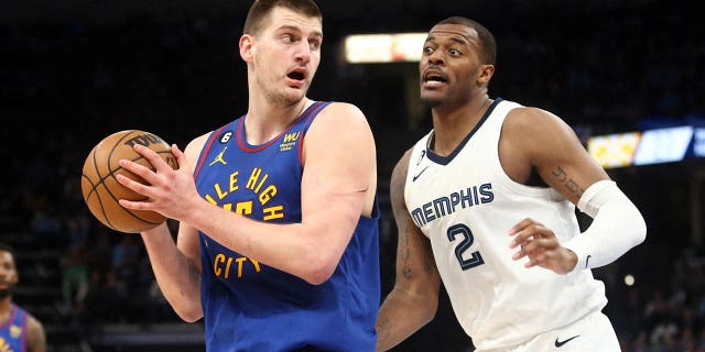 El centro de los Denver Nuggets, Nikola Jokic (15), corre hacia la canasta mientras el alero de los Memphis Grizzlies, Xavier Tillman (2), defiende durante la primera mitad en el FedEx Forum en Memphis el 25 de febrero de 2023.