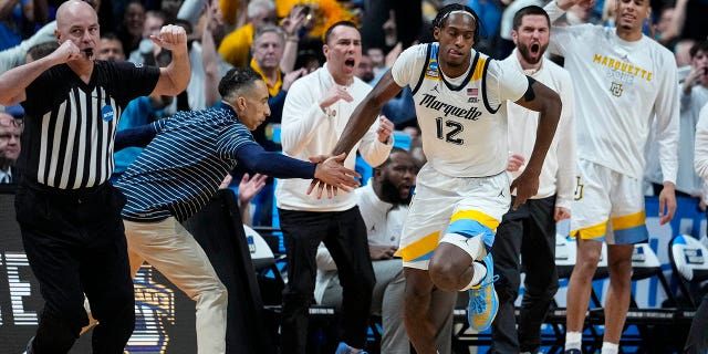 Marquette forward Olivier-Maxence Prosper (12) celebrates three-point basket with head coach Shaka Smart in the second half of a second-round college basketball game against Michigan State in the men's NCAA Tournament in Columbus, Ohio, Sunday, March 19, 2023.