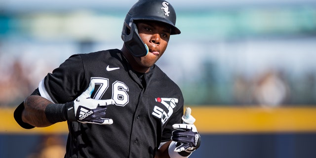 Oscar Colas #76 de los Medias Blancas de Chicago hace un gesto mientras redondea las bases después de conectar un jonrón en la octava entrada del juego de entrenamiento de primavera contra los Padres de San Diego en el Peoria Stadium el 11 de marzo de 2023 en Peoria, Arizona.