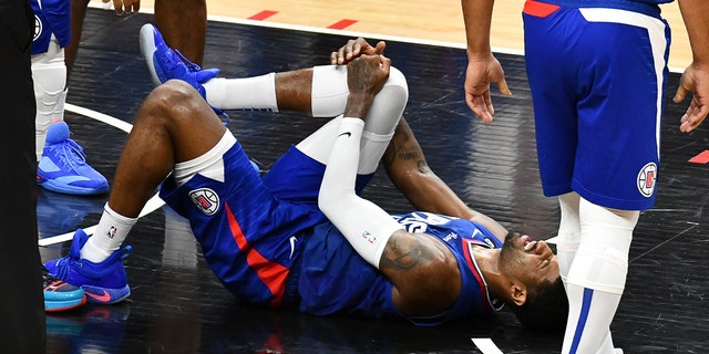 Paul George #13 of the Los Angeles Clippers suffers an apparent knee injury during a basketball game against the Oklahoma City Thunder at Crypto.com Arena on March 21, 2023 in Los Angeles, California. 