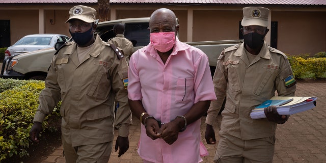 "Hotel Rwanda" hero Paul Rusesabagina (C) in the pink inmate's uniform arriving at Nyarugenge Court of Justice in Kigali, Rwanda, on Oct. 2, 2020, surrounded by guards of Rwanda Correctional Service (RCS).