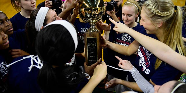 The Pennsylvania Quakers women's basketball team touch the championship trophy after the win against the Princeton Tigers in the Ivy League tournament final at The Palestra on March 12, 2017 in Philadelphia.