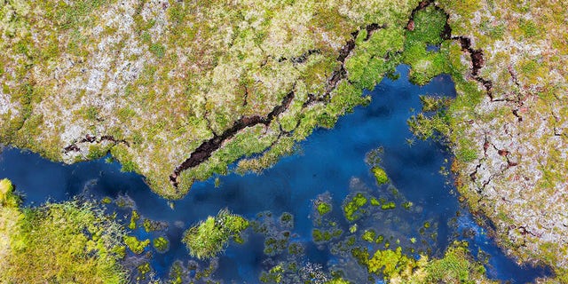  This aerial view taken on August 24, 2021, shows the pond at the Storflaket mire, an area where permafrost is studied by researchers looking into the impact of climate change near the village of Abisko, in Norrbotten County, Sweden.