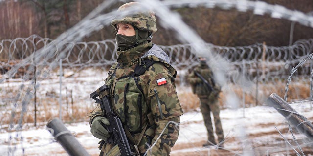 FILE: Polish army soldiers take part in a patrol by the barbed wire fence at the Polish Belarusian border during a media trip to the militarized area on January 13, 2022 in Kuznica, Poland.