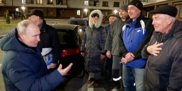 Russian President Vladimir Putin talks with local residents during his visit to Mariupol, Ukraine, over the weekend. A woman in this area was heard on video heckling Putin over the visit.