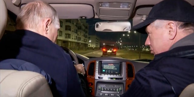 Russian President Vladimir Putin, left, and Russian Deputy Prime Minister Marat Khusnullin drive a car during their visit to Mariupol over the weekend.