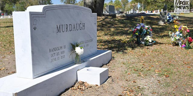 The headstone for Randolph Murdaugh III at Hampton Cemetery in Hampton, South Carolina, Sunday, March 5, 2023. He died three days after Maggie and Paul's murders. The temporary markers for the mother and son are to the right, surrounded by flowers. 