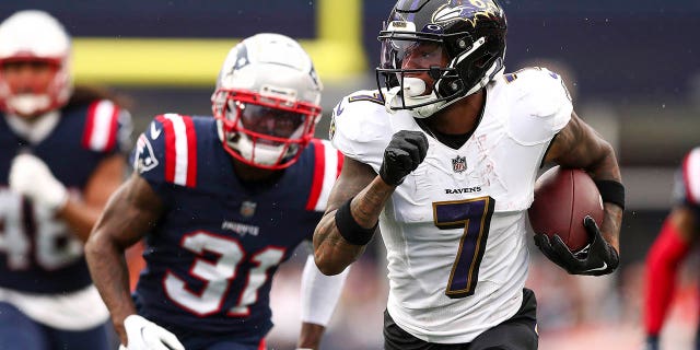 El receptor abierto No. 7 de los Baltimore Ravens, Rashod Bateman, ingresa al campo mientras el esquinero No. 31 de los New England Patriots, Jonathan Jones, persigue durante el cuarto cuarto en el Gillette Stadium el 25 2022 de septiembre en Foxborough, MA.