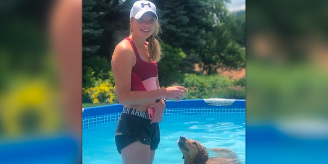 Julia Pernsteiner poses with her dog in a pool in an undated photograph. The Jacksonville University long-distance runner told police her coach "degraded her on a daily basis" and said she should "kill yourself" two weeks before she died of suicide.