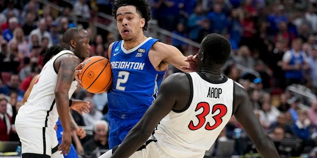 El guardia de Creighton, Ryan Nembhard (2), se encuentra con el alero de San Diego State, Aguek Arop (33), en la primera mitad de un partido de baloncesto universitario Elite 8 en la Región Sur del Torneo de la NCAA el domingo 26 de marzo de 2023, en Louisville, Ky.