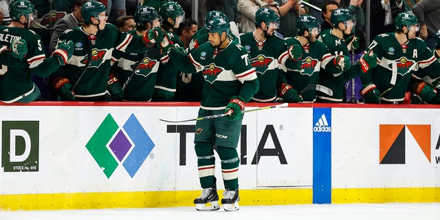 Ryan Reaves #75 de Minnesota Wild patina cerca del banco Wild y celebra su gol con sus compañeros en el segundo tiempo del partido contra Chicago Blackhawks en Xcel Energy Center el 25 de marzo de 2023 en St Paul, Minnesota.