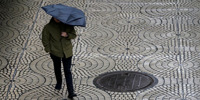 A pedestrian carries an umbrella while walking in San Francisco, Tuesday, March 14, 2023.