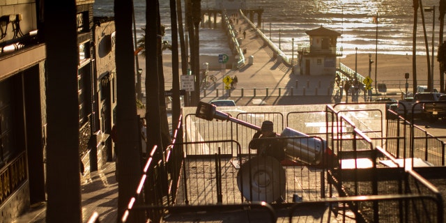 Workers with BrewCo, a craft beer hall serving food on Manhattan Beach Boulevard, works on dismantling their outdoor dining decks, in Manhattan Beach, California, March 1, 2023, a day after California's COVID-19 emergency officially ended. 