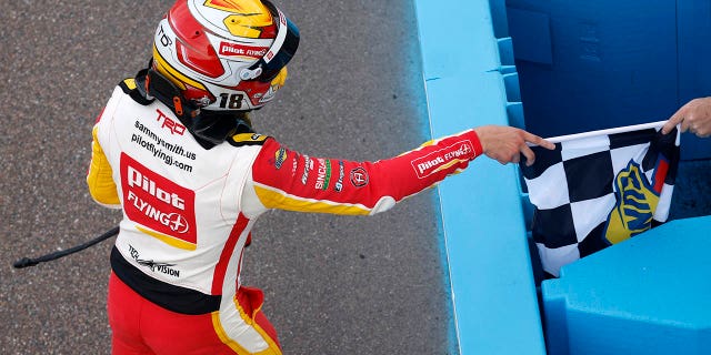 Sammy Smith, pengemudi #18 Pilot Flying J Toyota, menerima bendera kotak-kotak setelah memenangkan NASCAR Xfinity Series United Rentals 200 di Phoenix Raceway pada 11 Maret 2023 di Avondale, Arizona.