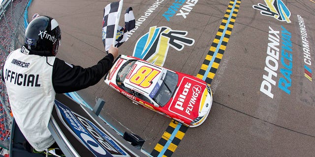 Sammy Smith, driver of the #18 Pilot Flying J Toyota, takes the checkered flag to wing the NASCAR Xfinity Series United Rentals 200 at Phoenix Raceway on March 11, 2023 in Avondale, Arizona.