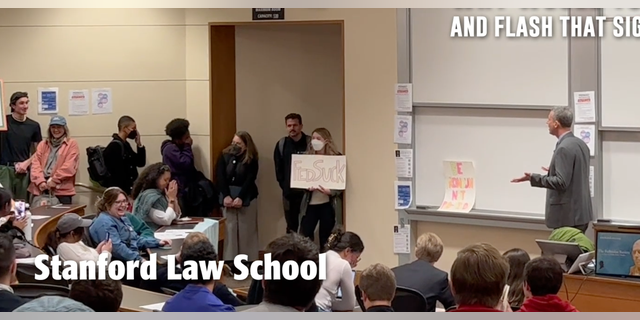 Stanford Law'ın çeşitlilik, eşitlik ve kapsayıcılıktan sorumlu dekan yardımcısı Tirien Steinbach protesto sırasında yüzünü kapatıyor.