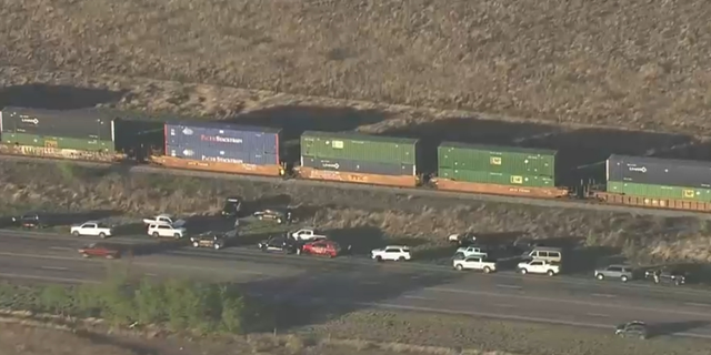 Vehicles and law enforcement officers were photographed by helicopter investigating train cars where more than a dozen migrants were found suffocated near San Antonio, TX. (Credit: KENS 5 San Antonio)