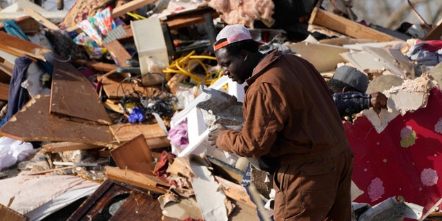 A resident looks through piles of debris, insulation and furnishings to see if anything can be salvaged at an RV park destroyed by a tornado in Rolling Fork, Mississippi March 25, 2023.  Emergency officials in Mississippi say several people were killed by tornadoes that swept through the state Friday night, destroying buildings and knocking out power, as storms produced hail the size of golf balls that ripped through several southern states. 