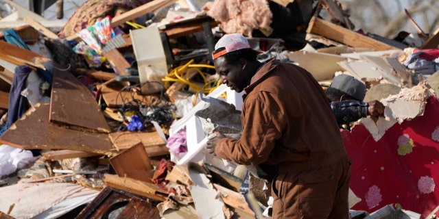 A resident looks through the piles of debris, insulation, and home furnishings to see if anything is salvageable at a tornado demolished mobile home park in Rolling Fork, Miss. March 25, 2023.  Emergency officials in Mississippi say several people have been killed by tornadoes that tore through the state on Friday night, destroying buildings and knocking out power as severe weather produced hail the size of golf balls moved through several southern states. 