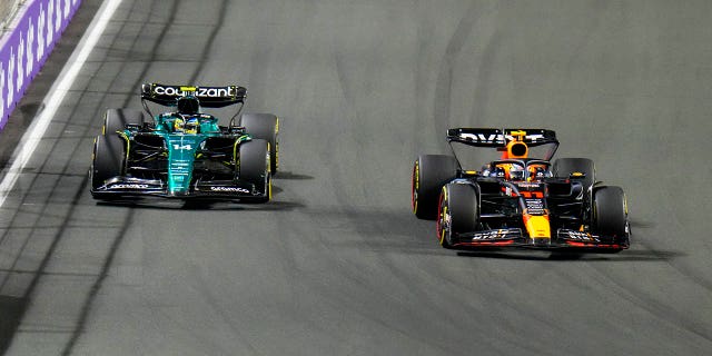 Red Bull driver Sergio Perez of Mexico takes over Aston Martin driver Fernando Alonso of Spain during the Saudi Arabia Formula One Grand Prix at the Jeddah corniche circuit in Jeddah, Saudi Arabia, Sunday, March 19, 2023.