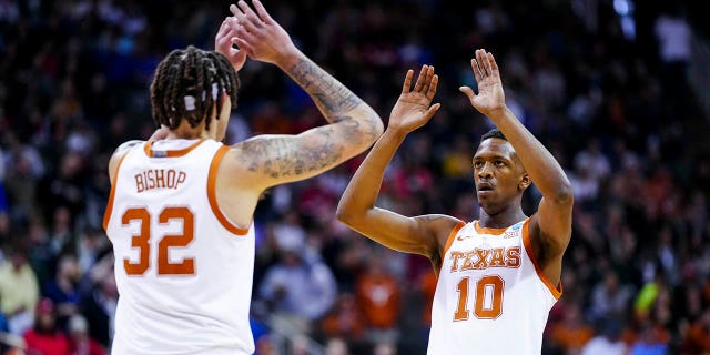 March 26, 2023;  Kansas City, MO, USA;  Texas Longhorns forward Christian Bishop (32) high-fives guard Sir'Jabari Rice (10) during a stoppage in the game against the Miami Hurricanes in the first half at the T-Mobile Center.