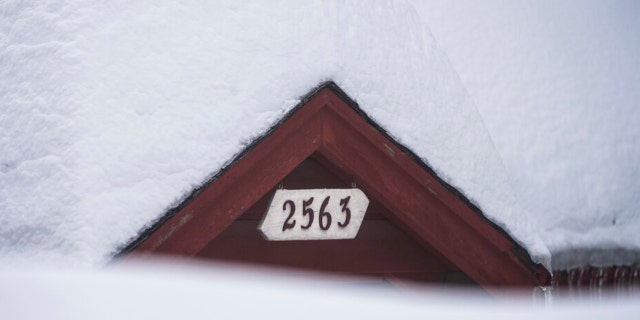 Snow is piled up on a home in Running Springs, Calif., Tuesday, Feb. 28, 2023. 