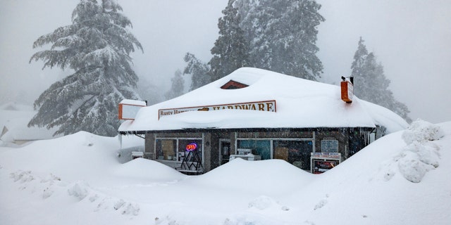 The open sign is still on at a business nevertheless shut down by the weather as residents throughout the San Bernardino Mountains remain trapped in their homes on March 1, 2023, in Running Springs, California. 
