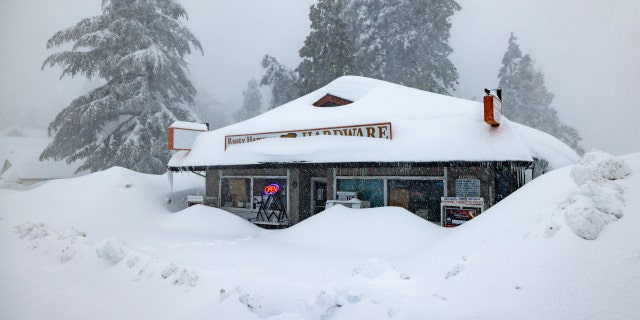 The open sign is still on at a business nevertheless shut down by the weather as residents throughout the San Bernardino Mountains remain trapped in their homes on March 1, 2023, in Running Springs, California. 