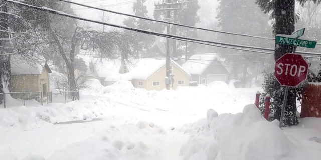 Snow blankets a street in Crestline, Calif., Saturday, Feb. 25, 2023. 