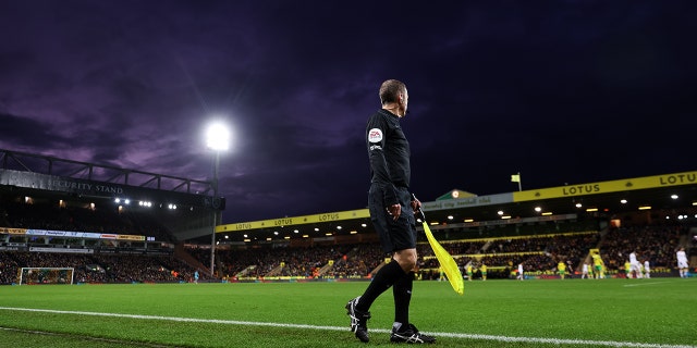 A general view of the assistant referee running the line at Carrow Road Stadium home of Norwich City during the Premier League match between Norwich City and Wolverhampton Wanderers at Carrow Road on November 27, 2021 in Norwich, England.