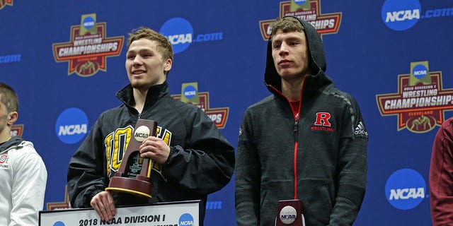 Spencer Lee de los Iowa Hawkeyes y Nick Suriano de los Rutgers Scarlet Knights suben al podio durante la sexta ronda de la NCAA.