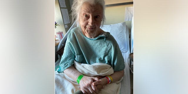 Alice Schuman, a Holocaust survivor, is shown during a hospital stay. Brock Cvijanovich, the new owner of the building where she lived, was right by her side when this photo was taken.