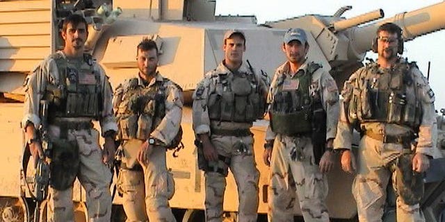 The team in front of a tank at Objective Grizzley, later FOB Grizzley, outside Tikrit, Iraq, April 12, 2003. Operators had taken control of a former Iraqi Army base. Tanks were flown into our area via the H1 Airfield to provide security for their new staging base and to provide fire support as they prepared to enter Tikrit. Pictured from left to right, Brad Thomas, Craig Palmer, Chris VanSant, Mike Hefner and Shawn Stevens.