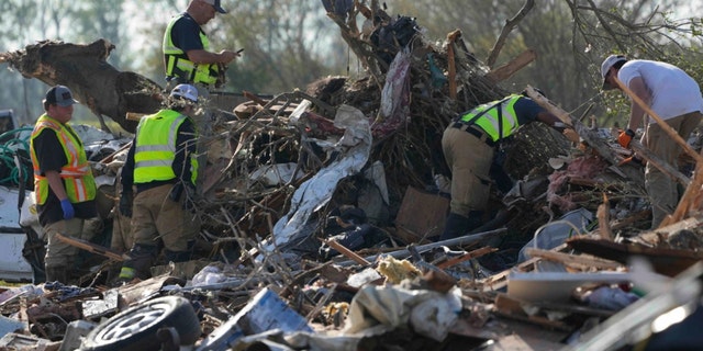 Emergency rescuers and first responders climb through a tornado demolished mobile home park looking for bodies that might be buried in the piles of debris, insulation, and home furnishings on March 25, 2023, in Rolling Fork, Miss.