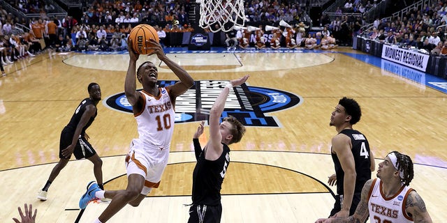 Sir'Jabari Rice, number 10 of the Texas Longhorns, drives to the basket against Adam Kunkel, number 5 of the Xavier Musketeers, during the first half of the Sweet 16 round of the NCAA Men's Basketball Tournament at the T-Mobile Center on March 24.  , 2023, in Kansas City, Missouri.