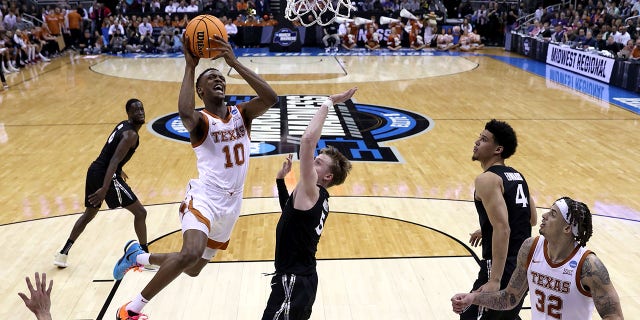 Texas Longhorns'un 10 numarası Sir'Jabari Rice, 24 Mart'ta T-Mobile Center'da düzenlenen NCAA Erkekler Basketbol Turnuvasının Sweet 16 raundunun ilk yarısında Xavier Musketeers'ın 5 numarası Adam Kunkel'e karşı potaya gidiyor 2023, Kansas City, Missouri'de.