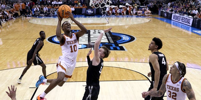 Sir'Jabari Rice, number 10 of the Texas Longhorns, drives to the basket against Adam Kunkel, number 5 of the Xavier Musketeers, during the first half of the Sweet 16 round of the NCAA Men's Basketball Tournament at the T-Mobile Center on March 24.  , 2023, in Kansas City, Missouri.