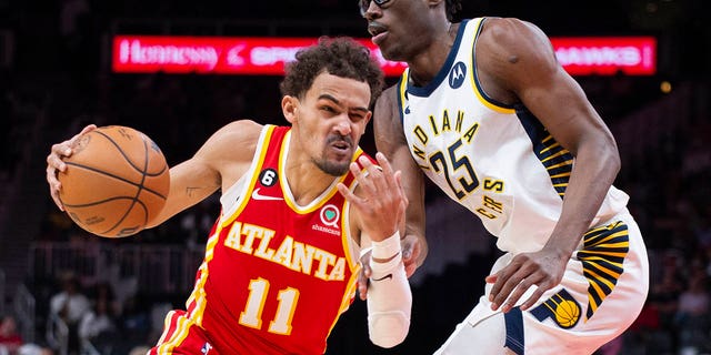 El escolta de los Hawks, Trae Young, pasa junto al alero de los Indiana Pacers, Jalen Smith, el sábado 25 de marzo de 2023 en Atlanta.