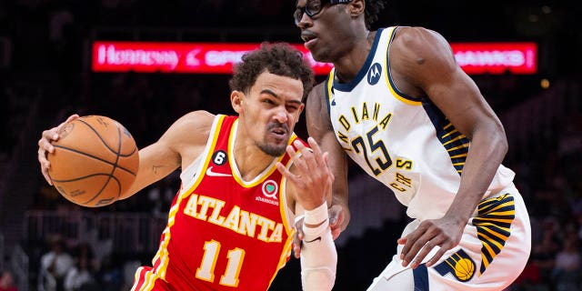 El escolta de los Hawks, Trae Young, pasa junto al alero de los Indiana Pacers, Jalen Smith, el sábado 25 de marzo de 2023 en Atlanta.