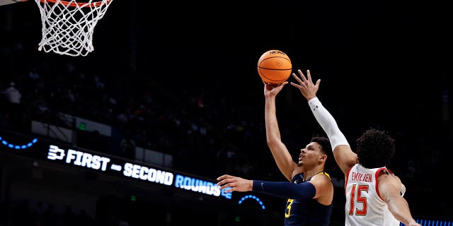 El alero de Virginia Occidental Tre Mitchell (3) lanza un tiro mientras el alero de Maryland Patrick Emilien (15) defiende en la primera mitad de un partido de baloncesto universitario de primera ronda en el Torneo de la NCAA en Birmingham, Alabama, el jueves 16 de marzo de 2023. 