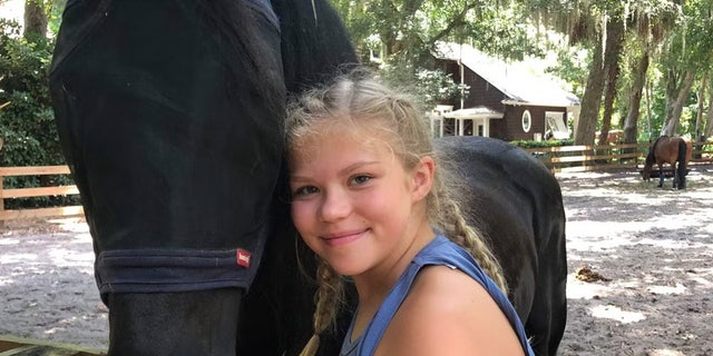 Tristyn Bailey con un caballo negro.  Fue apuñalada fatalmente por su compañero de clase Aiden Fucci el 9 de mayo de 2021 en Florida.
