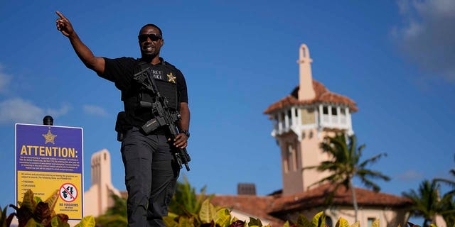 A Secret Service agent told the passerby to keep moving, as he watched over the wall surrounding former President Trump's Mar-a-Lago.