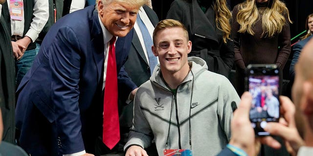 Former President Donald Trump, left, poses for a photo with Virginia wrestler Justin McCoy at the NCAA Championship Wrestling Championship, Saturday, March 18, 2023, in Tulsa, Oklahoma.