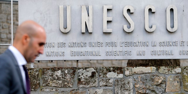 La agencia de la ONU pide a los gobiernos que implementen el marco ético global para la IA 6 Un hombre pasa junto al logo de la Organización de las Naciones Unidas para la Educación, la Ciencia y la Cultura (UNESCO) en París, Francia.