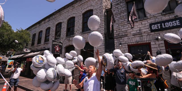 Family members, friends and Austin community members release balloons in memory of Doug Kantor in downtown Austin, Texas, on June 12, 2022.