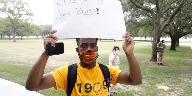  University of South Florida student Jason Berry wears a face mask while protesting in front of the residence where USF President Steven Currall lives on campus on July 2, 2020 in Tampa, Florida. (Photo by Octavio Jones/Getty Images)