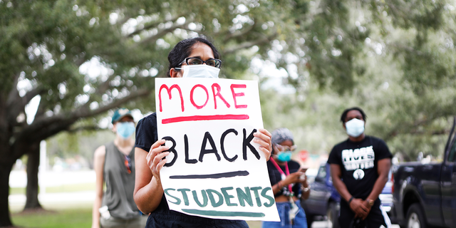 A University of South Florida student wears a face mask while protesting in front of the residence where USF President Steven Currall lives on campus on July 2, 2020 in Tampa, Florida. (Photo by Octavio Jones/Getty Images)