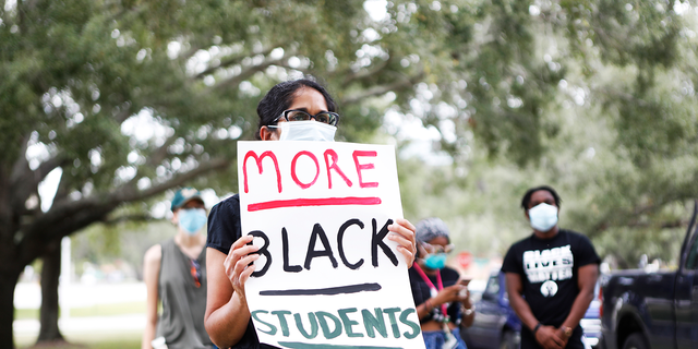 A University of South Florida student wears a face mask while protesting outside USF President Steven Currall's residence on campus on July 2, 2020 in Tampa, Florida.  (Photo by Octavio Jones/Getty Images)