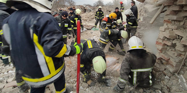 Rescue workers sift through the rubble of residential buildings in the Lviv region March 9 which were destroyed by a Russian rocket attack.