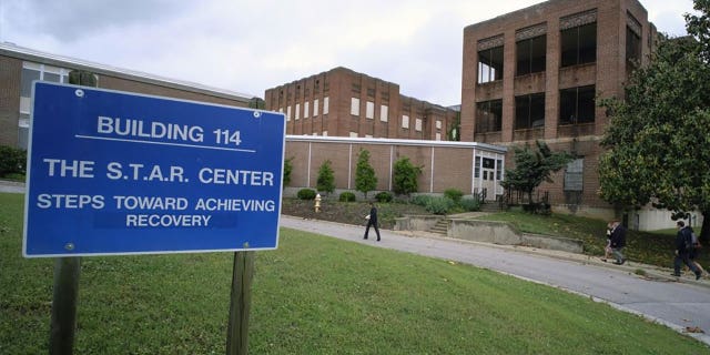 Visitors walk toward a building at Central State Hospital in Virginia on May 17, 2018. Seven deputies were charged with second-degree murder after a Black man died at the Central State Hospital. 